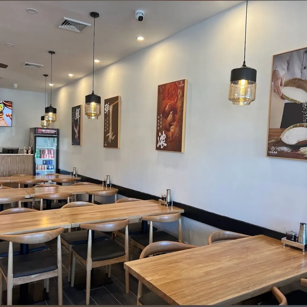 Bright dining area with wall art and pendant lights at Ten Seconds Yunnan Rice Noodle, a Chinese Restaurant in Syosset