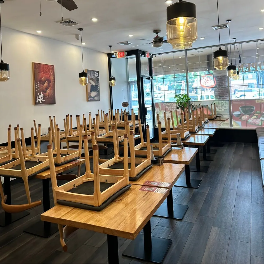 Modern restaurant interior with wooden tables and chairs at Ten Seconds Yunnan Rice Noodle, a Chinese Restaurant in Syosset